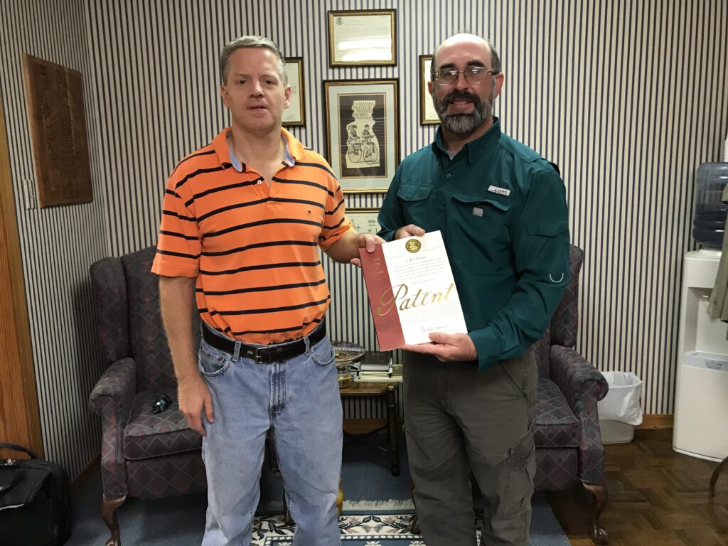 Two Men with a Patent Certificate